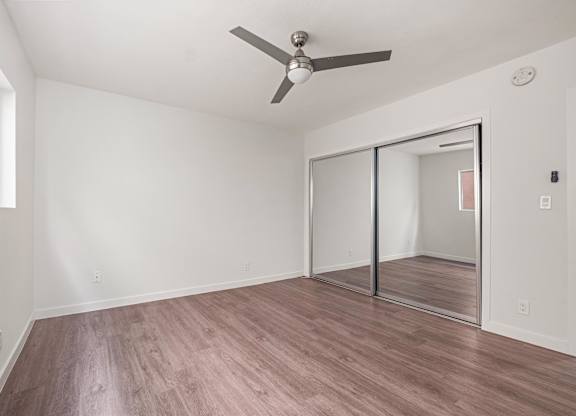 A room with a ceiling fan and a sliding glass door at Menlo Terrace Apartments, California