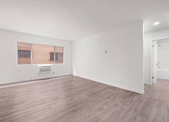 Room with wooden floors, window at Menlo Terrace Apartments, Los Angeles, CA, 90006