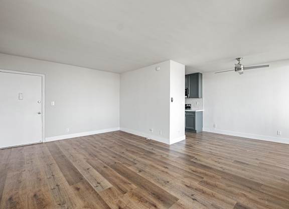 A room with wooden floors and white walls at Menlo Terrace Apartments, Los Angeles, CA