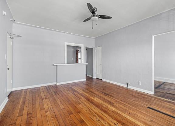 A room with a ceiling fan and wooden floors at Normandie Summit Apartments, Los Angeles, 90004
