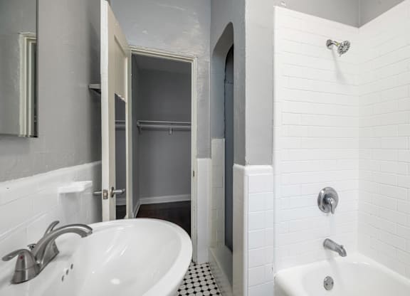 A white bathroom with a sink and a shower at Normandie Summit Apartments, Los Angeles