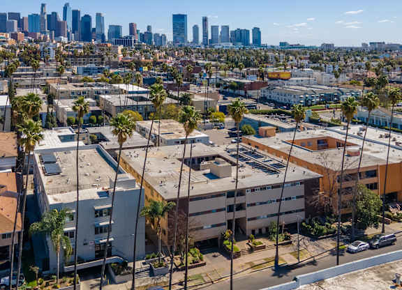 A cityscape with buildings and palm trees.at Palms at Menlo, Los Angeles, 90006 