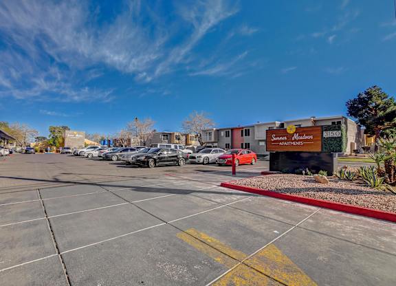 A parking lot with cars and a building with a sign that says