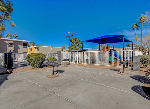 A sunny day at the community pool with a blue shade structure.