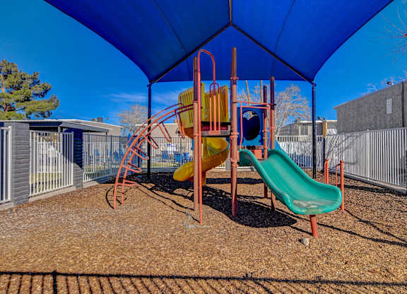 A playground with a blue canopy and a yellow slide.