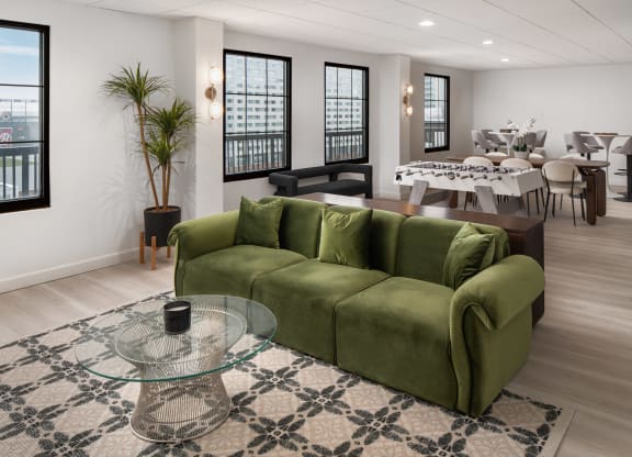 a living room with a green couch and a glass coffee table at Vision on Lombard, Baltimore, MD 21201