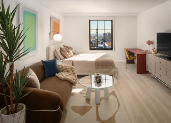 a living room with a couch and a bed in a room at Vision on Lombard, Baltimore, MD 21201
