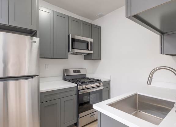 A kitchen with a stainless steel refrigerator, microwave, and oven at Westmore Manor Apartments, Los Angeles, CA, 90020