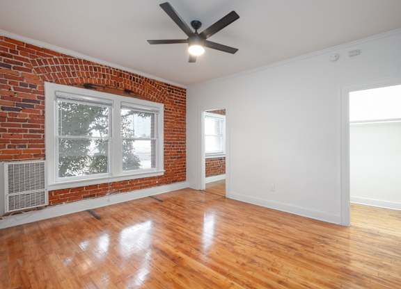 A room with a ceiling fan and wooden floors at Westmore Manor Apartments, Los Angeles, 90020