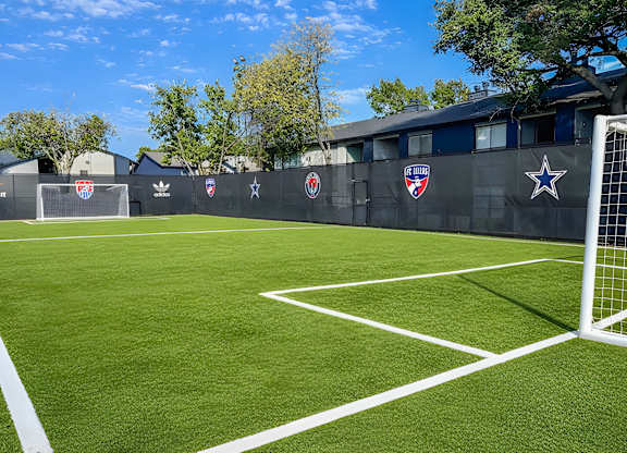 A soccer field with a goal on the right side.