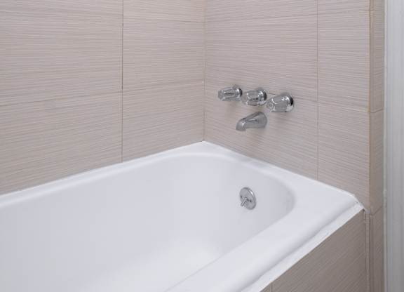 A white bathtub with a shower head above it at Mariposa Willows Apartments, California, 90004