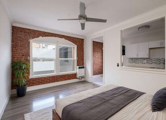 A bedroom with a bed, a ceiling fan, and a potted plant at Mariposa Willows Apartments, Los Angeles