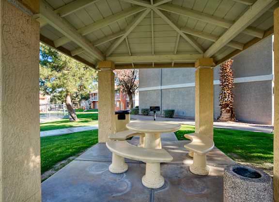 A white pedestal sink is in the middle of a concrete patio.