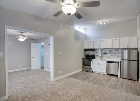 a living room with a ceiling fan and a kitchen with stainless steel appliances at Valencia Park, Phoenix, Arizona, 85008