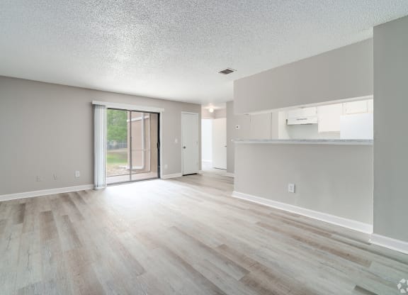 an empty living room and kitchen with a sliding glass door to a patio at Village Lakes, Orlando, FL, 32808