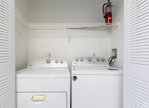 an empty laundry room with two washes and a dryer