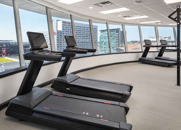 a row of treadmills in a gym with a view of the city at Vision On Lombard Baltimore, MD