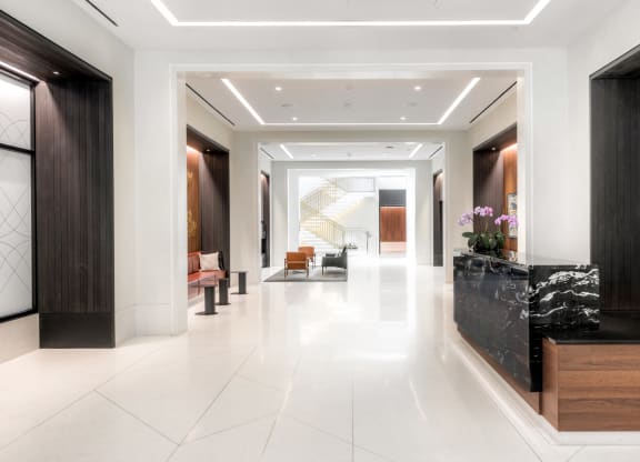 lobby with concierge desk, seating and fireplace at the grace apartments in arlington, va