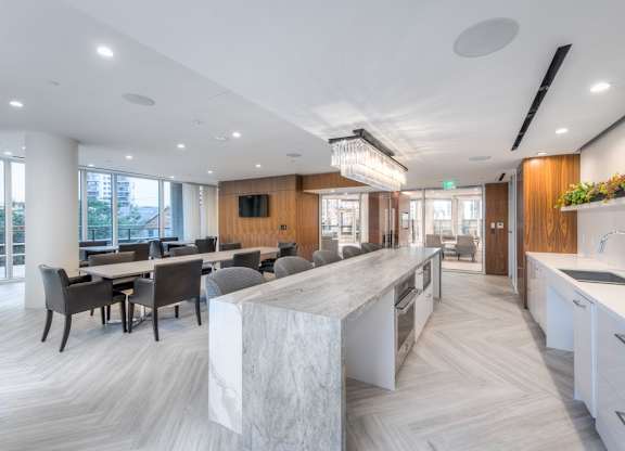 A modern kitchen with a marble island and wooden accents.