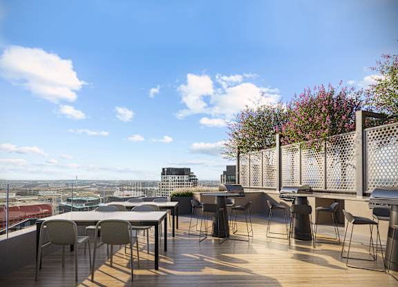 A patio with a table and chairs overlooking a cityscape.