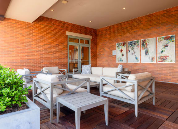 a patio with white furniture and a brick wall