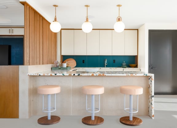 a kitchen with pink stools and white cabinets and a counter at The Grace and Reva, Virginia