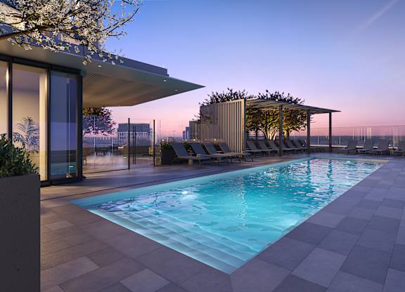 A modern pool area with a sun lounger and a tree.