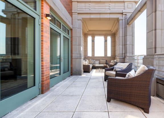 a patio with chairs and couches on a balcony