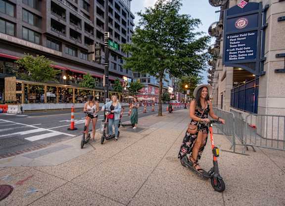A woman riding an electric scooter on a city street.