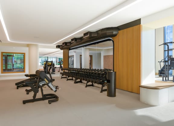 a gym with a row of weights machines and a wooden wall at The Grace and Reva, Arlington, Virginia