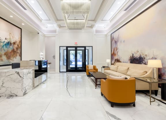 a lobby with white marble floors and a marble reception desk