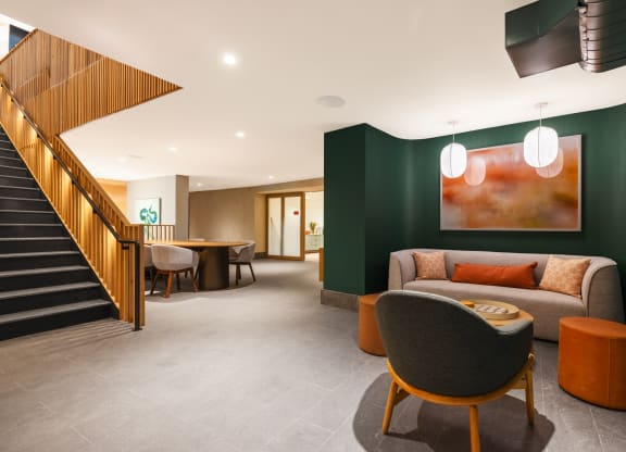 a lounge area with chairs and tables and a staircase at The Grace and Reva, Arlington, VA