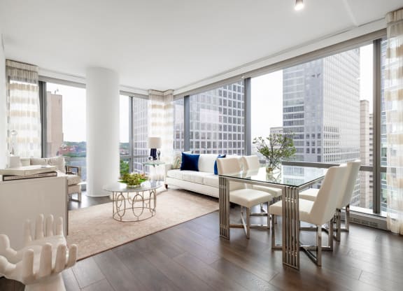 a living room with a large window and a table with chairs