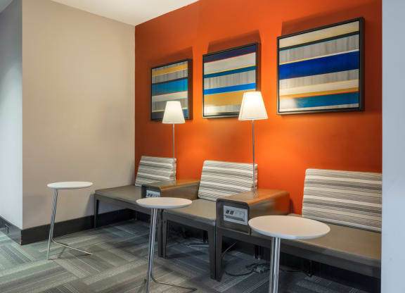 a waiting room with four tables and chairs and three lamps