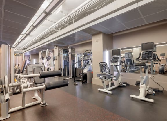 a gym with various machines and weights in a building