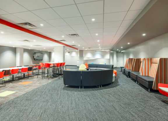 a lounge area in a large room with chairs and couches