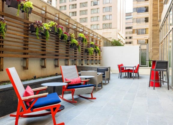 a patio with chairs and tables on a building