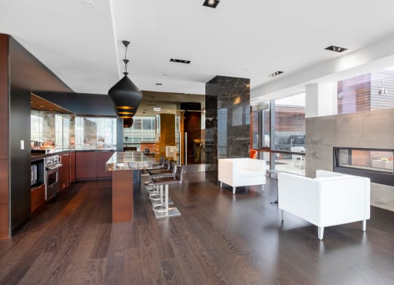 a large kitchen and living room with white furniture and a fireplace