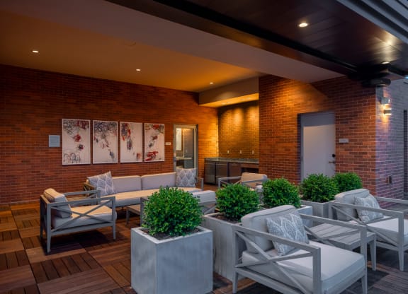 a patio with a couch and chairs and a sink in the background