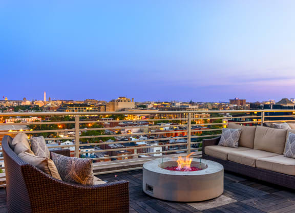 a patio with a firepit and two couches on a wooden deck with a view of