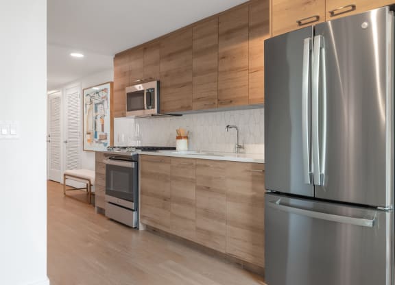 a kitchen with stainless steel appliances and wooden cabinets at The Grace and Reva, Virginia