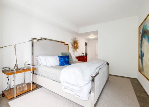 a white bedroom with a bed and a nightstand