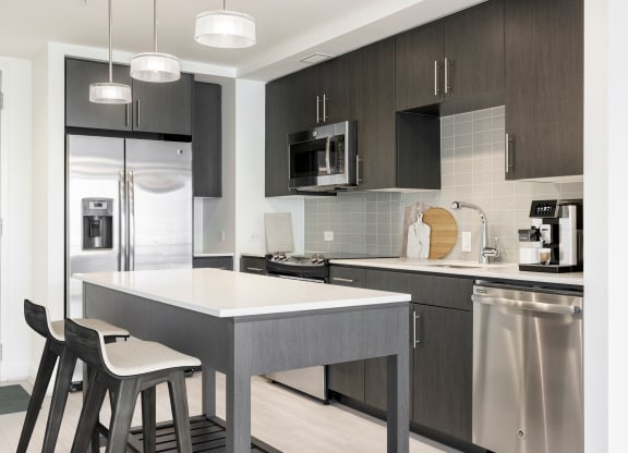 a kitchen with a large island with two stools