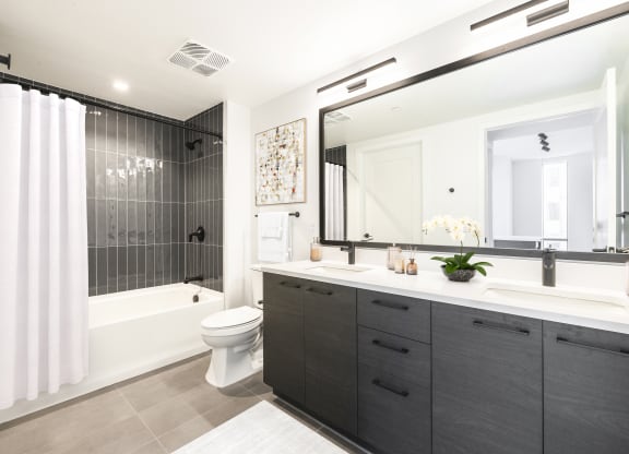 a bathroom with a large mirror and a shower and a toilet at The Grace and Reva, Arlington, VA
