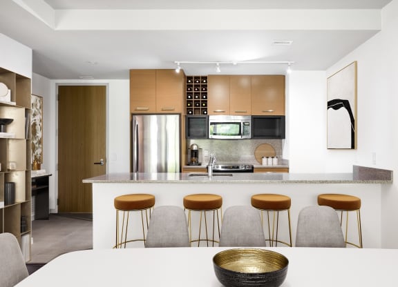 a kitchen with a white table and four stools