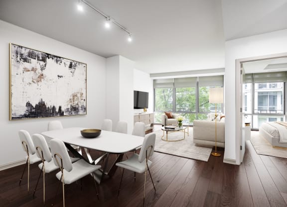 a dining area with a white table and chairs and a tv on the wall