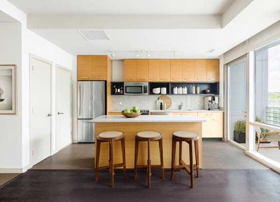 a kitchen with wooden cabinets and an island with three stools