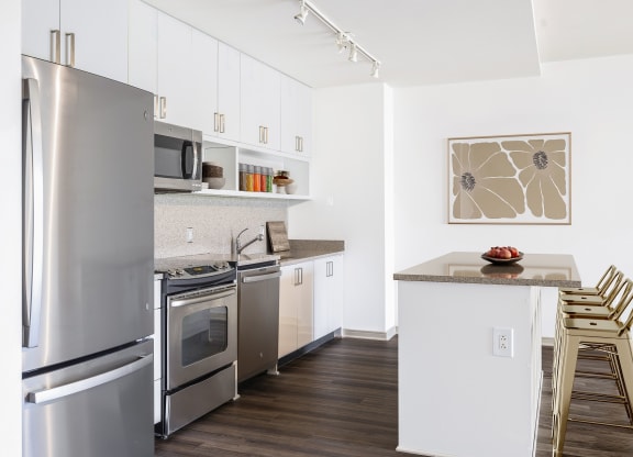 a kitchen with white cabinets and stainless steel appliances