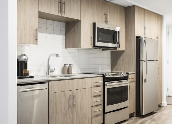 a kitchen with wooden cabinets and stainless steel appliances