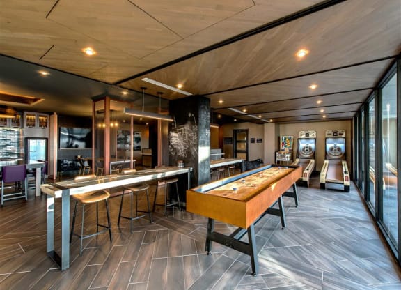 a recreation room with a shuffleboard table and a foosball table